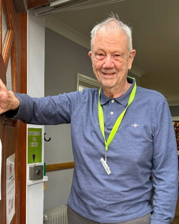Man holds door of Hospice open for visitors