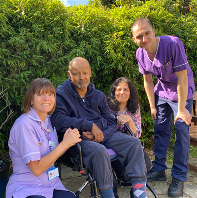 Patient with clinical staff in hospice garden