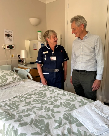 Man stands in front of Hospice Inpatient Unit bed